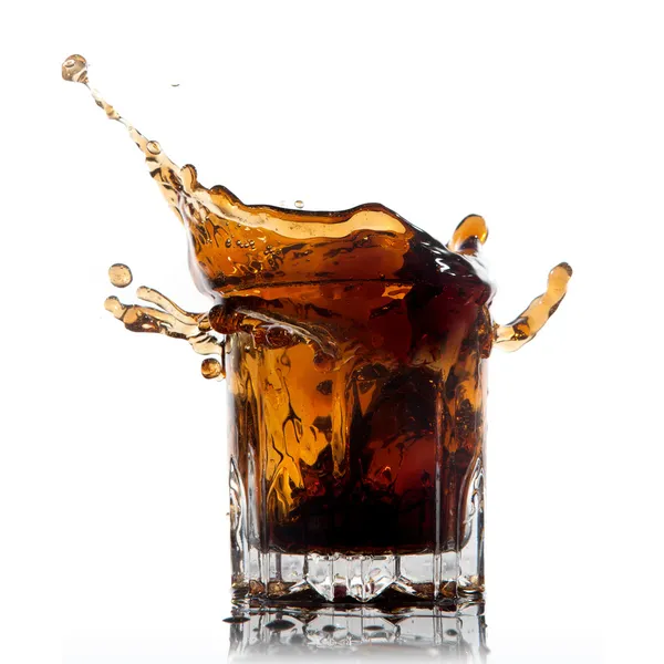 Splash of cola in glass isolated on white — Stockfoto