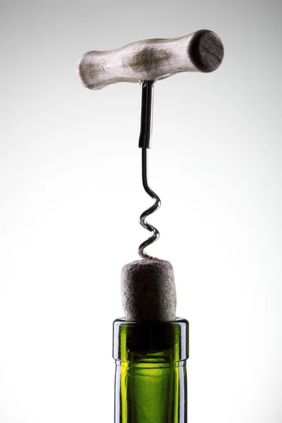 Korkenzieher, der in eine Weinsicherung in einer Flasche auf Weiß eingesetzt wird — Stockfoto