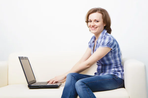 Young slender woman with a laptop — Stockfoto