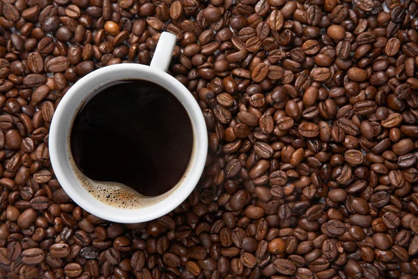 Kaffeetasse auf dem Hintergrund von Bohnen — Stockfoto