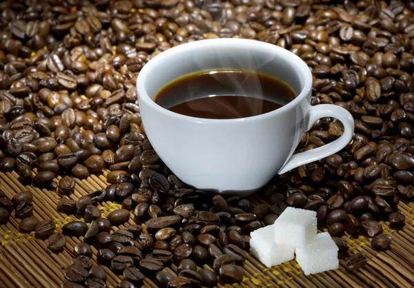 Kaffeetasse mit Zucker auf gerösteten Bohnen — Stockfoto