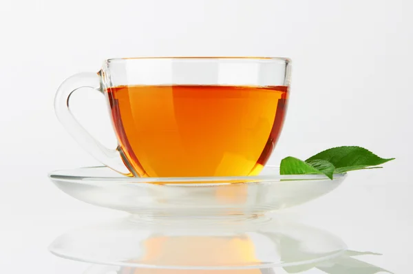 Hrnek s čajem a zelený list — Stock fotografie
