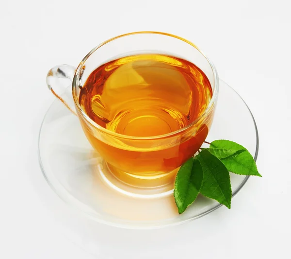 Kopp med te och grönt blad — Stockfoto