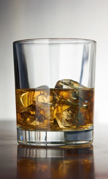 Whiskey with ice cubes on abstract — Stock Photo, Image