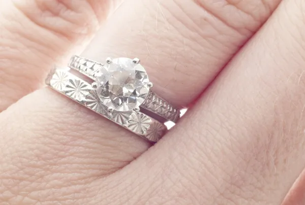 Anel de casamento de diamante antigo e banda no dedo — Fotografia de Stock