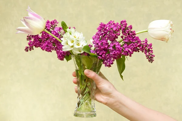 Női kéz gazdaság virágok. — Stock Fotó