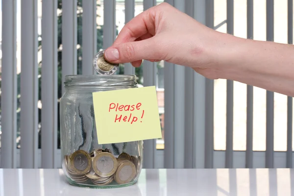Mão colocar moeda para doações jar . — Fotografia de Stock