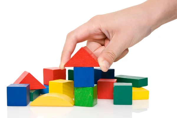 Mão fazem um edifício de blocos coloridos. — Fotografia de Stock