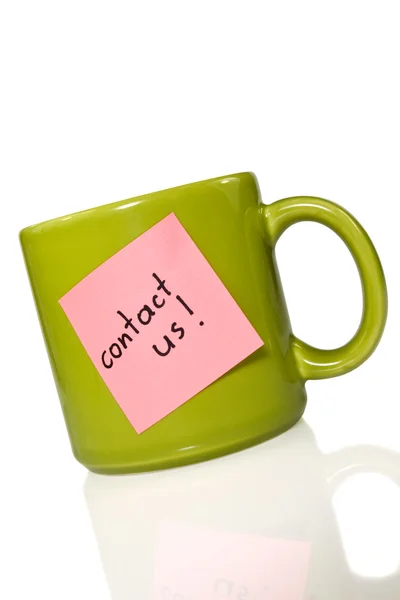 Cup with note "contact us!". — Stock Photo, Image