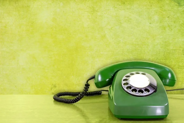 Telefono contro il muro verde. — Foto Stock