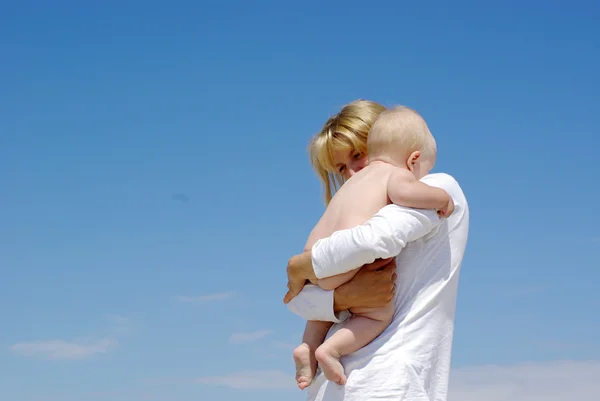 Feliz madre y bebé jugando sobre un fondo azul del cielo —  Fotos de Stock