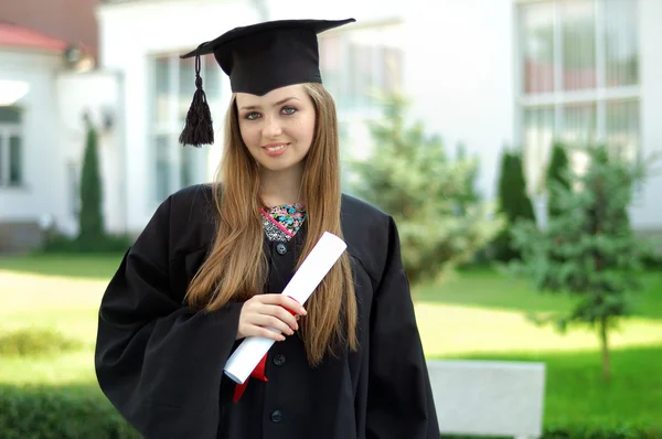 Examen med ett diplom som ser in i kameran — Stockfoto