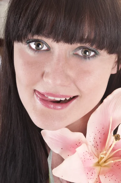 Mooie jonge vrouw met roze bloem — Stockfoto