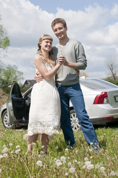 Felice giovane coppia in piedi vicino alla macchina — Foto Stock
