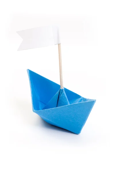 Голубая оригами-лодка с флагом — стоковое фото