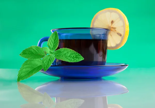 Boa xícara de chá e hortelã no fundo verde — Fotografia de Stock