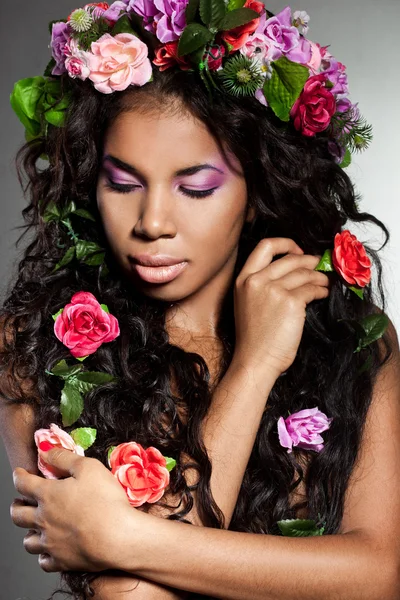 Elegante mulat meisje met circlet van bloemen — Stockfoto