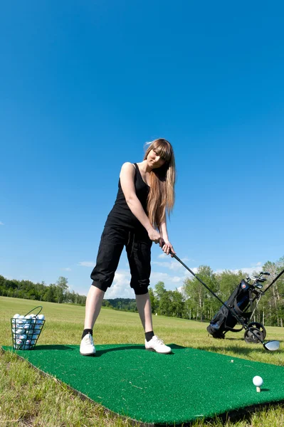 Жінка збирається вдарити м'яч для гольфу — стокове фото