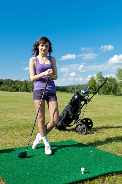 Woman about to strike golf ball — Stock Photo, Image