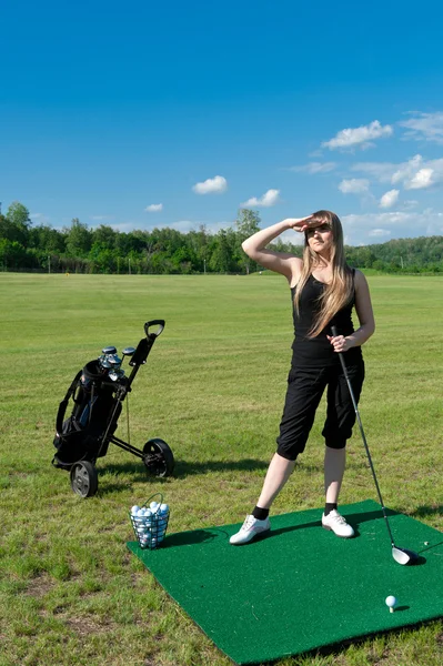 Woman about to strike golf ball — Stock Photo, Image