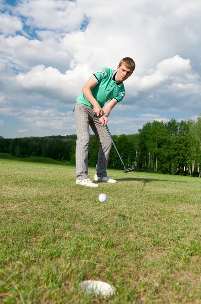 Golf verde hoyo hombre de campo de poner la bola dentro de putt corto — Foto de Stock