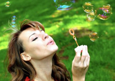 Young girl blowing soap bubbles clipart