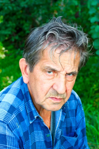Серьезный пожилой человек в летнем парке — стоковое фото