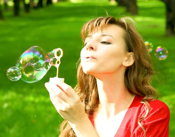 Jovem menina soprando bolhas de sabão — Fotografia de Stock