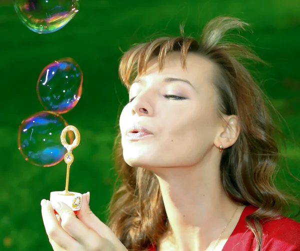 Young girl blowing soap bubbles — Stock Photo, Image