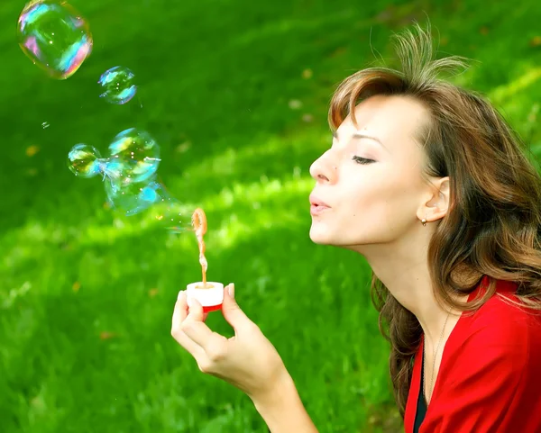 Молода дівчина дме мильні бульбашки — стокове фото