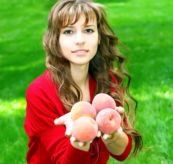 Söt tjej med persikor — Stockfoto