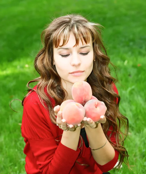Menina bonito com pêssegos — Fotografia de Stock