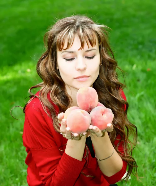 Söt tjej med persikor — Stockfoto