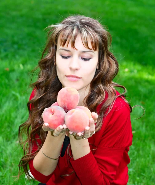 Cute girl with peaches — Stock Photo, Image