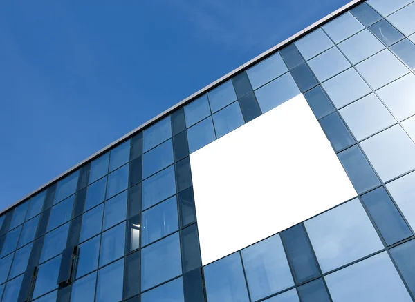 Transparente Glaswand mit leerem Plakat eines Wolkenkratzers — Stockfoto