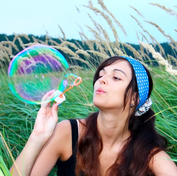 Young girl blowing a big soap bubble — Stock Photo, Image