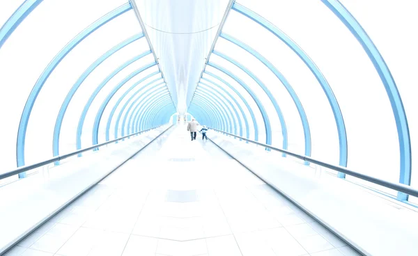 Light corridor in airport with curved glass wall, moving
