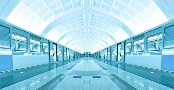 Symmetriska belysta tunnelbanestation med marmorgolv — Stockfoto