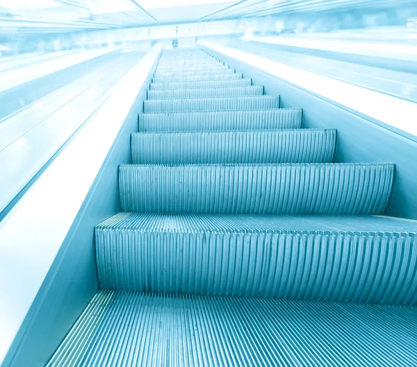現代的な建物の中動いているエスカレーターの青い手順 — ストック写真