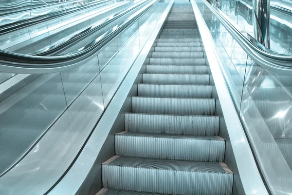 Contemporary moving escalator stairs inside business blue hall — Stock Photo, Image