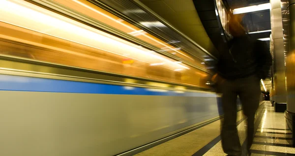 Рухомий поїзд та особи на станції метро — стокове фото