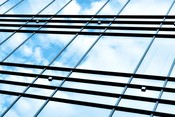 Vakre skyer reflektert i glassvegg – stockfoto