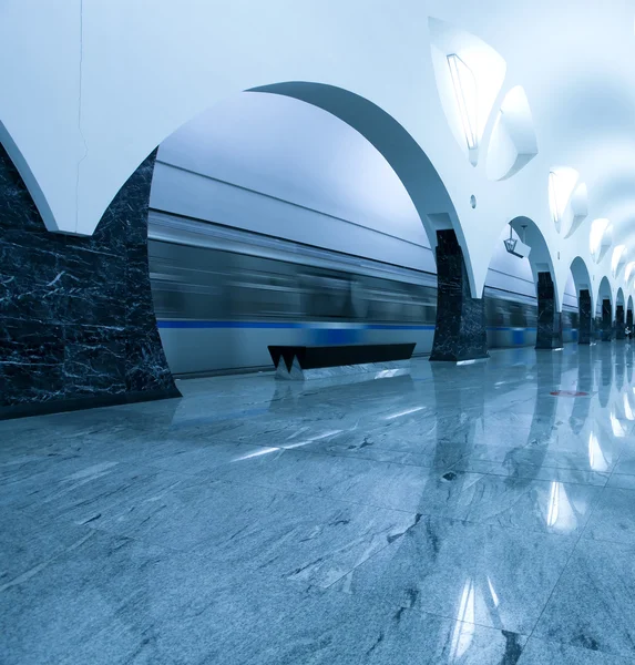 Verlichte metro station met trein in beweging — Stockfoto