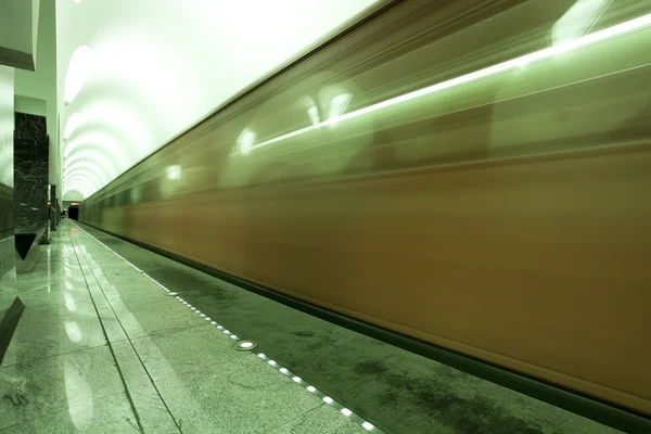 Fast moving train on underground platform — Stock Photo, Image