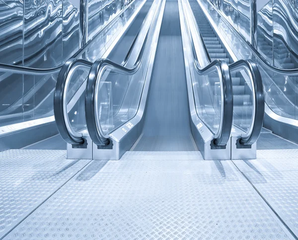 Black moving escalator stairs inside business blue hall — Stock Photo, Image