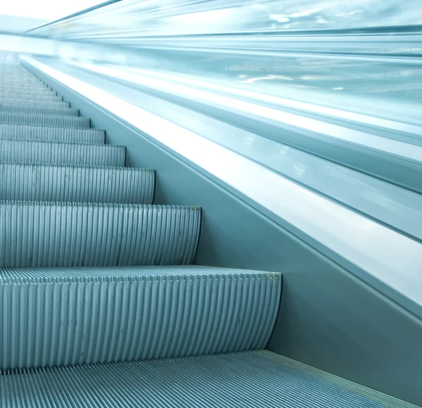 Contemporary moving escalator stairs inside business blue hall — Stock Photo, Image