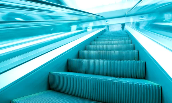 Vista angular a los pasos verdes modernos de las escaleras mecánicas de negocios en movimiento —  Fotos de Stock