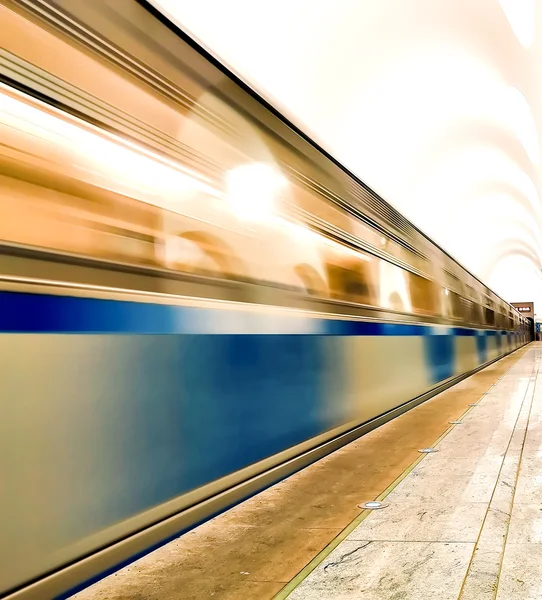Undeground platfom met kolommen en rijdende trein — Stockfoto