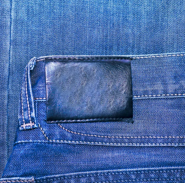 Siyah deri etiket denim doku içinde izole — Stok fotoğraf