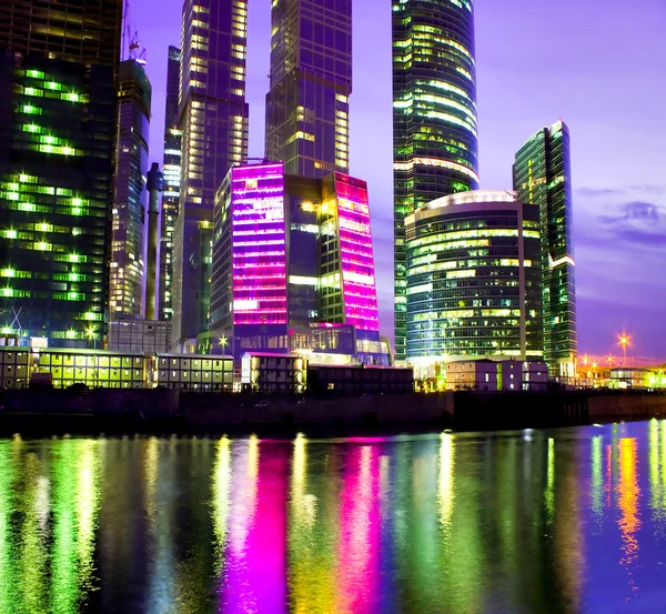 Rascacielos iluminados de vidrio por la noche — Foto de Stock
